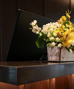 Hotel Reception Desk with Black Computer And White And Yellow Flowers