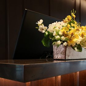 Hotel Reception Desk with Black Computer And White And Yellow Flowers